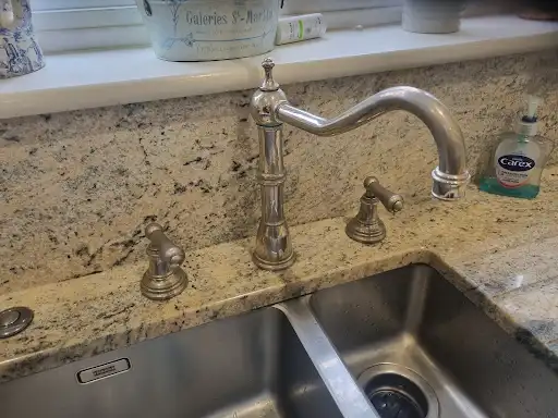 Traditional kitchen mixer tap installed on granite worktop